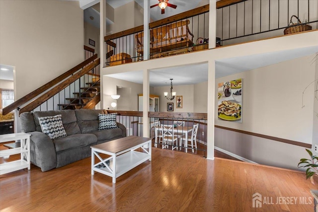 295 Gemini Dr Unit 3D, Hillsborough, NJ 08844 - living area with a towering ceiling, stairs, a ceiling fan, wood finished floors, and a chandelier