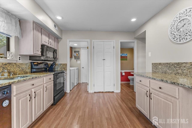 295 Gemini Dr Unit 3D, Hillsborough, NJ 08844 - kitchen with black appliances, independent washer and dryer, a sink, light wood-style floors, and light stone countertops
