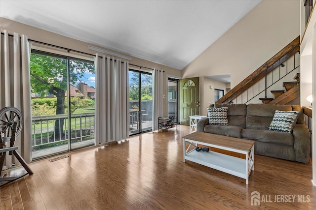 295 Gemini Dr Unit 3D, Hillsborough, NJ 08844 - living area featuring stairway, wood finished floors, and high vaulted ceiling