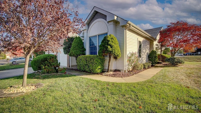 view of side of property with a lawn