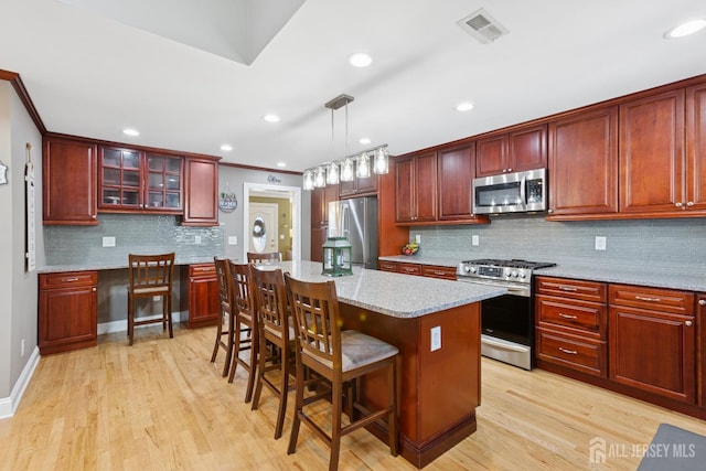 3223 Banta Rd, South Plainfield, NJ 07080 - kitchen featuring appliances with stainless steel finishes, dark brown cabinets, tasteful backsplash, a kitchen island, and light wood finished floors
