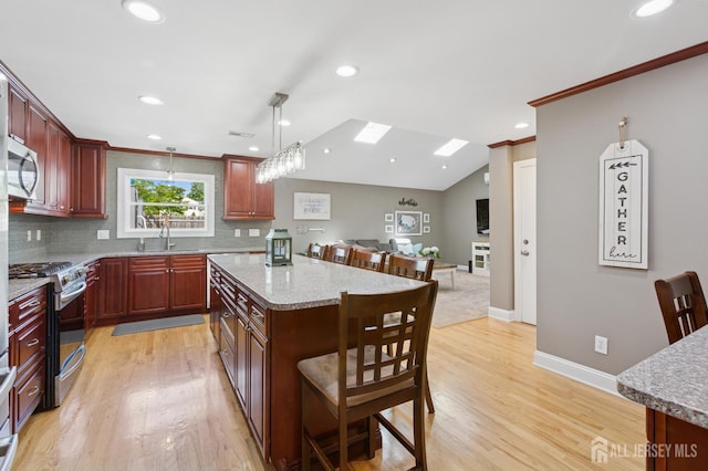 3223 Banta Rd, South Plainfield, NJ 07080 - kitchen with appliances with stainless steel finishes, a kitchen breakfast bar, decorative backsplash, a kitchen island, and ornamental molding