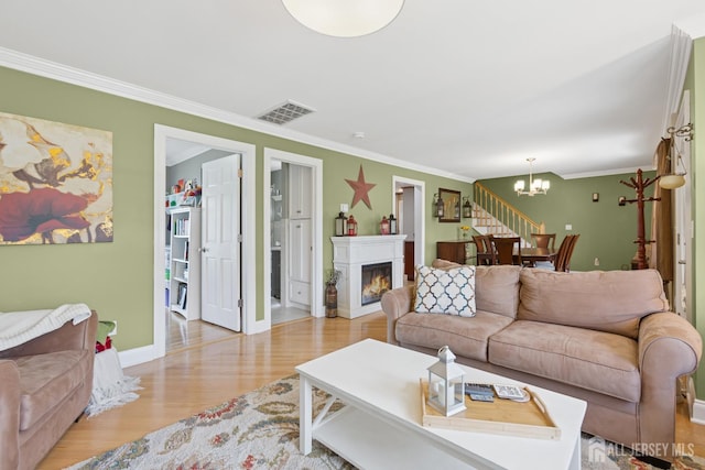 3223 Banta Rd, South Plainfield, NJ 07080 - living area with wood finished floors, a chandelier, ornamental molding, baseboards, and a lit fireplace