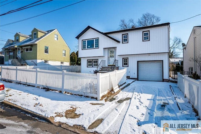 bi-level home featuring a fenced front yard and an attached garage