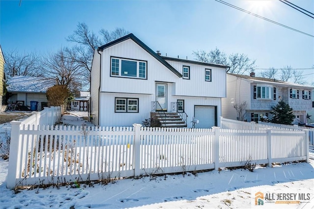 view of front of property with an attached garage and a fenced front yard