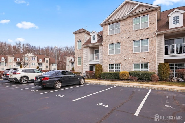 view of property featuring uncovered parking and a residential view