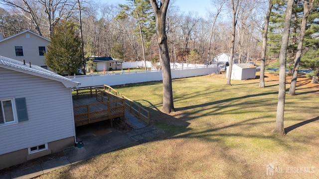 view of yard with a wooden deck and a storage shed