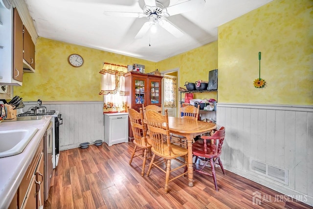 29 Pulawski Ave, South River, NJ 08882 - dining room with wainscoting, light wood-type flooring, a ceiling fan, and wood walls