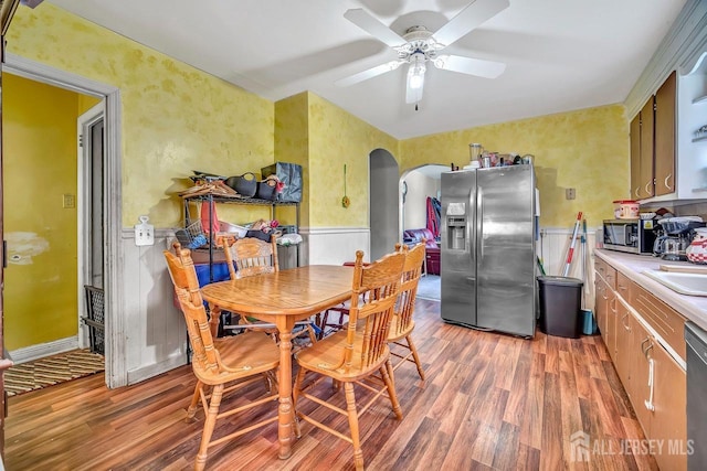 29 Pulawski Ave, South River, NJ 08882 - dining space with arched walkways, light wood-style floors, wainscoting, and ceiling fan