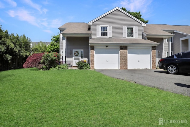 view of front of home featuring driveway, brick siding, an attached garage, a front yard, and a shingled roof