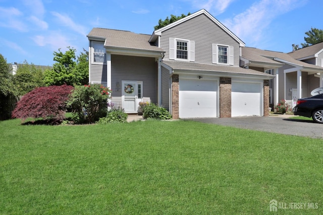 view of front of home featuring asphalt driveway, a front yard, an attached garage, brick siding, and roof with shingles