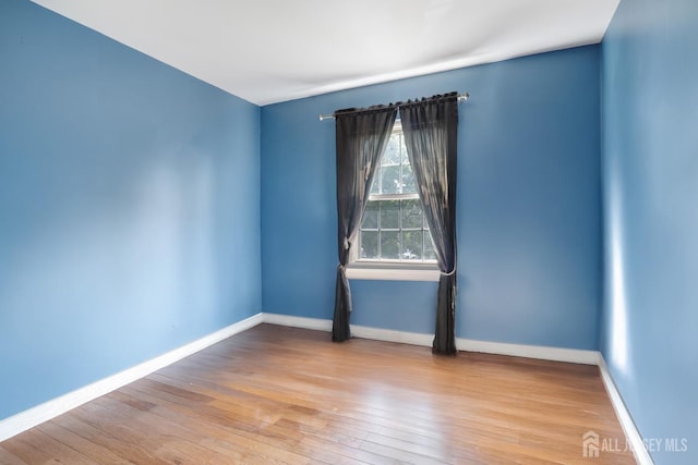 unfurnished room with wood finished floors and baseboards
