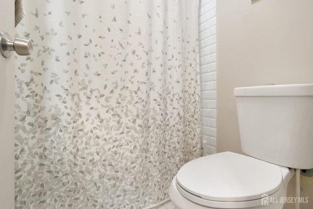 bathroom with toilet and curtained shower