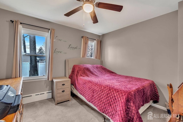 bedroom with a baseboard heating unit, light colored carpet, a ceiling fan, and baseboards