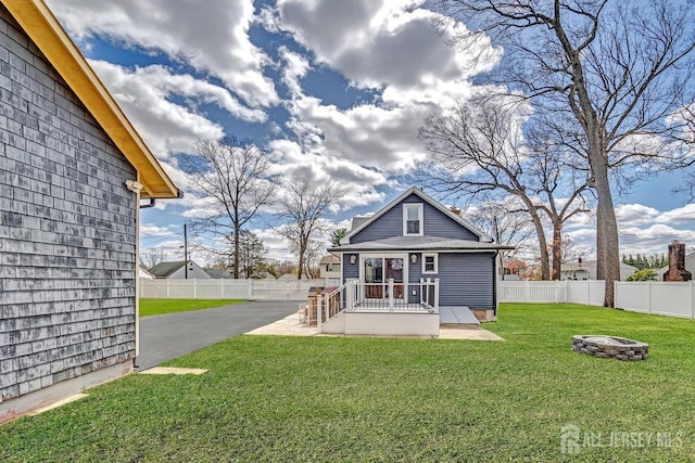 back of house featuring a fire pit and a patio