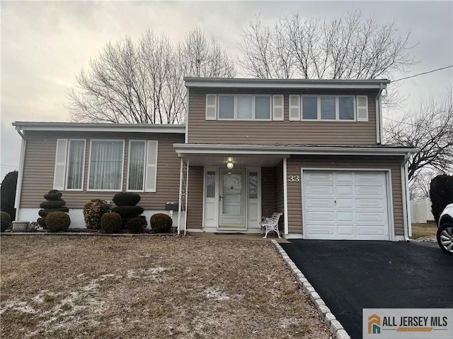 split level home featuring aphalt driveway and an attached garage