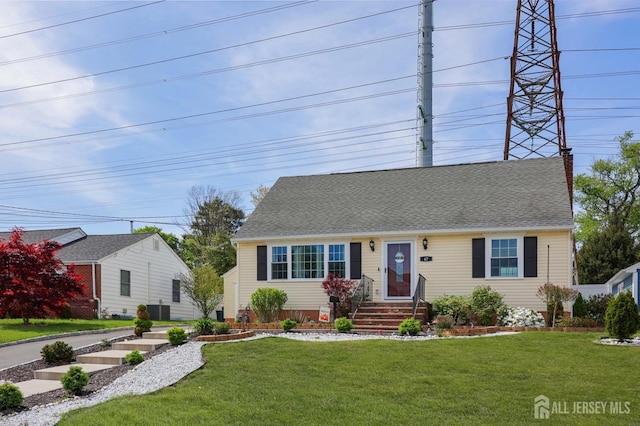 cape cod home with a shingled roof, central air condition unit, and a front yard
