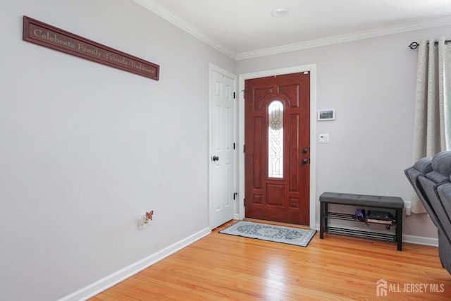entryway with baseboards, ornamental molding, and light wood-type flooring