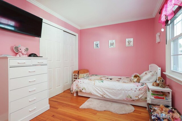 bedroom featuring crown molding, a closet, and wood finished floors