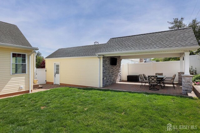 back of house featuring a yard, fence, a patio area, and roof with shingles