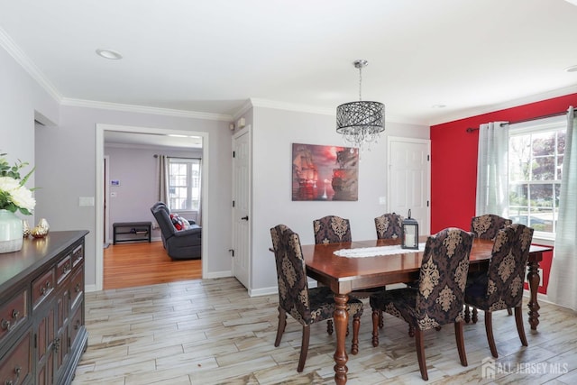 dining room with crown molding, baseboards, a notable chandelier, and light wood-type flooring