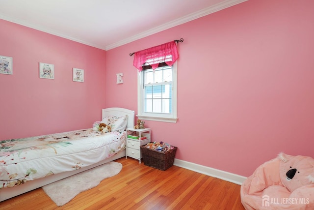 bedroom featuring baseboards, ornamental molding, and light wood-style flooring