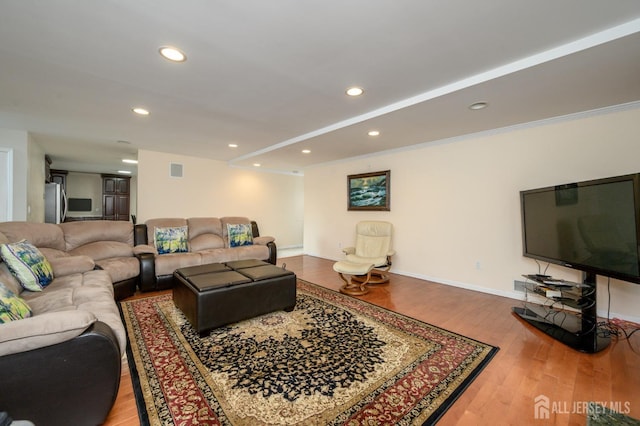 living area featuring wood finished floors, baseboards, and recessed lighting