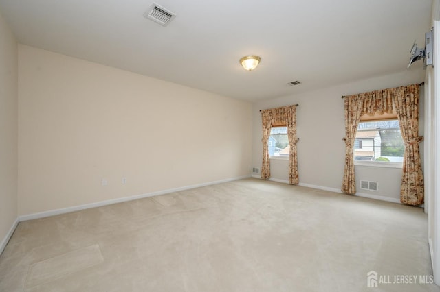 unfurnished room with baseboards and light colored carpet