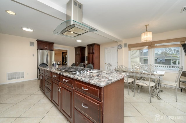 kitchen with island exhaust hood, appliances with stainless steel finishes, light tile patterned flooring, dark brown cabinets, and baseboards