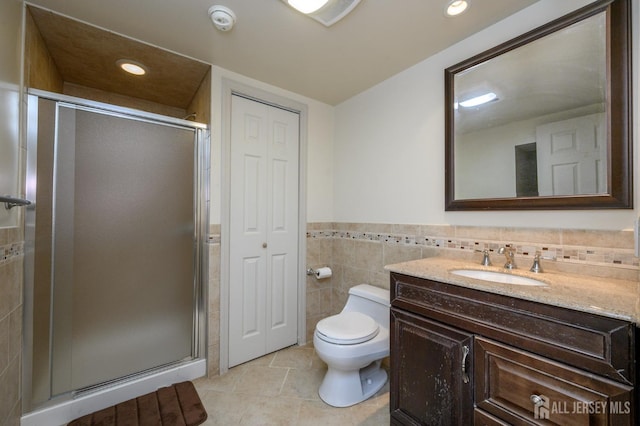 full bathroom featuring tile walls, a stall shower, vanity, tile patterned floors, and toilet
