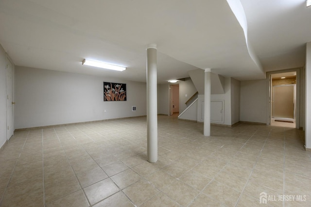 finished basement with light tile patterned floors and stairs