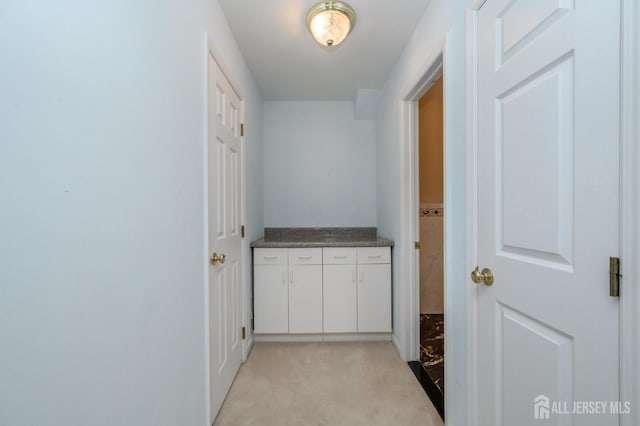 hallway featuring light colored carpet