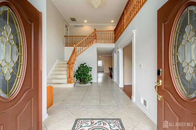 foyer with light tile patterned floors, baseboards, stairs, recessed lighting, and crown molding
