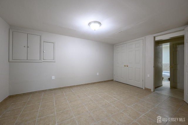 unfurnished bedroom with a closet and light tile patterned floors