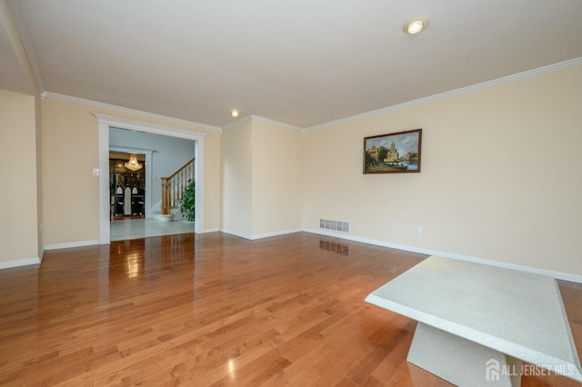 spare room with light wood-style floors, crown molding, baseboards, a chandelier, and recessed lighting