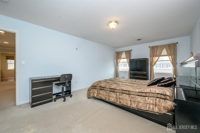 carpeted bedroom with baseboards and a desk