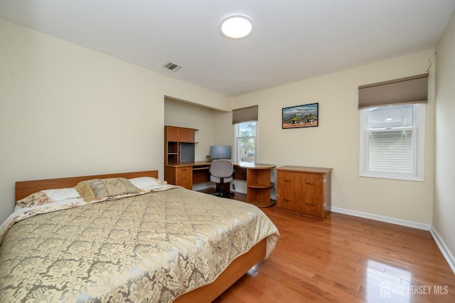bedroom with light wood-style flooring and baseboards