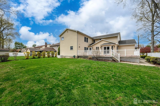 rear view of house featuring a wooden deck