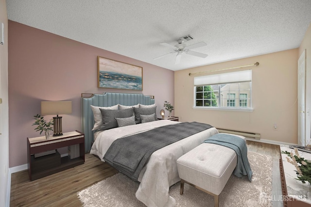 639 Madison Dr Unit C, Monroe, NJ 08831 - bedroom with a baseboard heating unit, a textured ceiling, wood finished floors, baseboards, and a ceiling fan