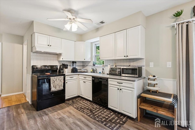 383 S Stump Tavern Rd S, Jackson, NJ 08527 - kitchen featuring black appliances, under cabinet range hood, dark wood-type flooring, white cabinetry, and wainscoting