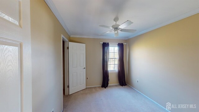 unfurnished bedroom with light colored carpet, ceiling fan, and crown molding