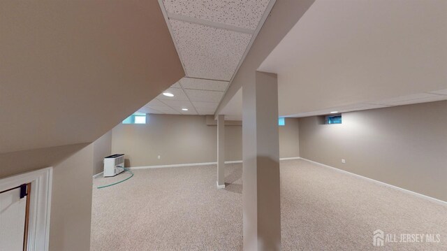 basement featuring carpet floors and a paneled ceiling