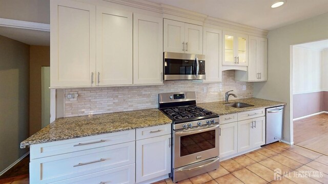 kitchen with sink, stainless steel appliances, white cabinetry, and tasteful backsplash