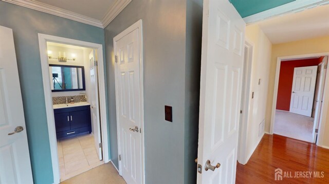 corridor featuring tile patterned floors and crown molding