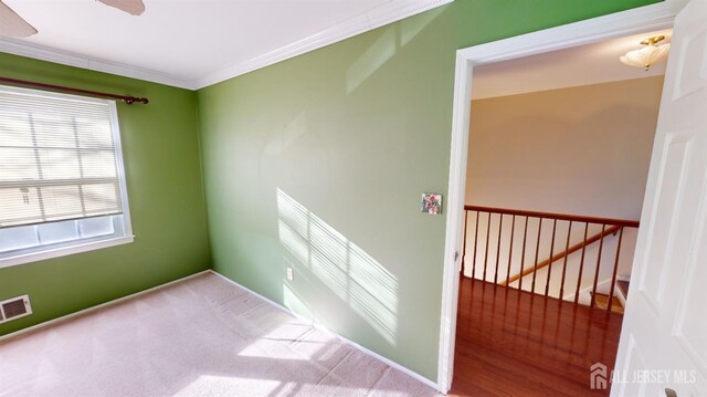 carpeted spare room with crown molding