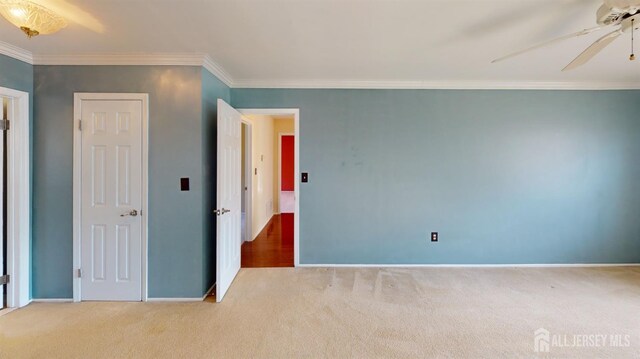 unfurnished bedroom with ceiling fan, crown molding, and light colored carpet