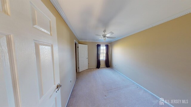 unfurnished bedroom featuring ceiling fan, light carpet, and crown molding