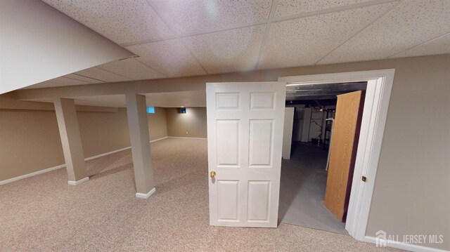 basement with light colored carpet and a drop ceiling