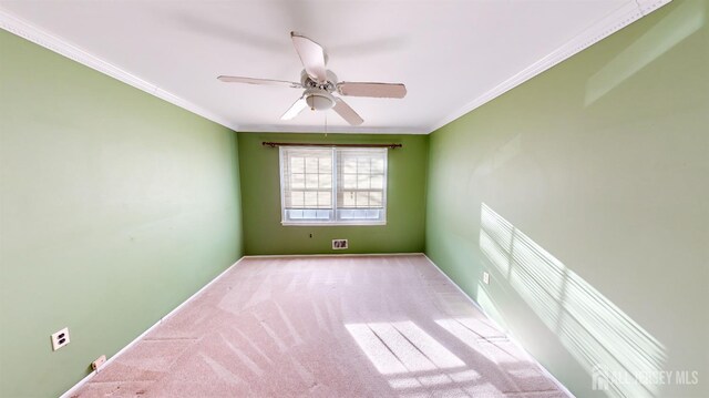 unfurnished room featuring ceiling fan, light colored carpet, and ornamental molding