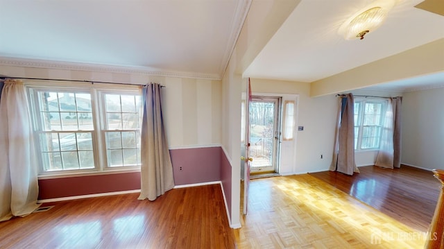 entrance foyer featuring ornamental molding, plenty of natural light, and hardwood / wood-style flooring